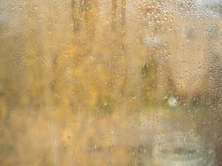 Rain drops on glass, bokeh background Copy space