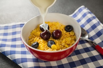 Milk being poured into bowl of wheaties cereal