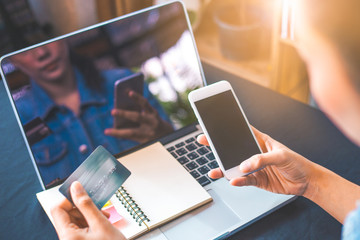 Women hold credit cards and use mobile phones to shopping online.