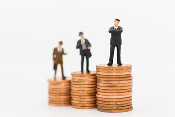 Miniature people: Business man standing on stack of coin using as background Money and financial concepts.