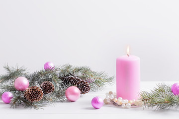 Christmas decoration with pink candle on white background