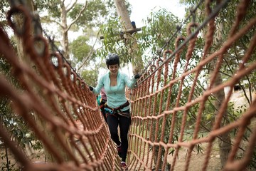 Woman walking on rope bridge