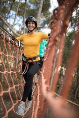 Woman walking on rope bridge