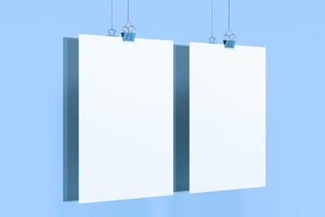 Two blank white posters with binder clip mockup on blue background