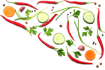 mix red hot chili peppers with parsley and sliced cucumber and carrot isolated on white background top view