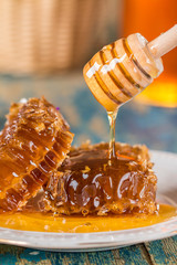 Honeycombs on plate on wooden background