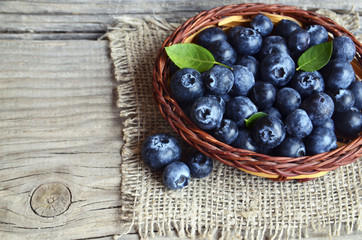 Freshly picked blueberries in a basket on old wooden background.Fresh organic blueberry. Bilberries.Healthy eating,vegan diet or raw food concept.Selective focus.