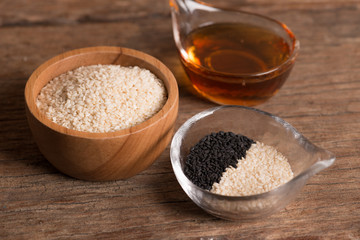 Sesame seeds and sesame oil on a old wooden table