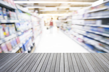 Empty top of wooden table and supermarket blur background