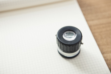 lupe with note on the wooden desk.