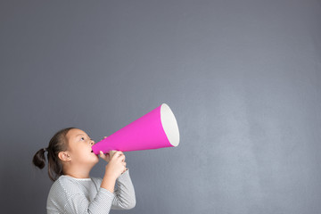 Kid shouting through pink paper megaphone.