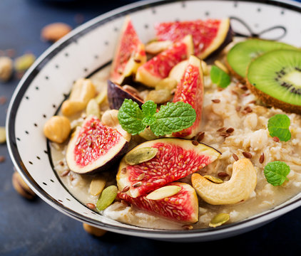 Delicious and healthy oatmeal with figs, nuts, kiwi and seeds. Healthy breakfast. Fitness food. Proper nutrition.