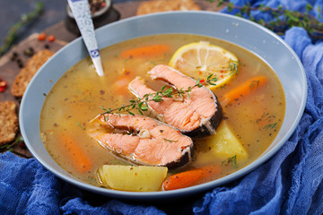 Salmon fish soup with vegetables in bowl.