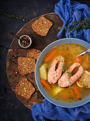 Salmon fish soup with vegetables in bowl. Flat lay. Top view