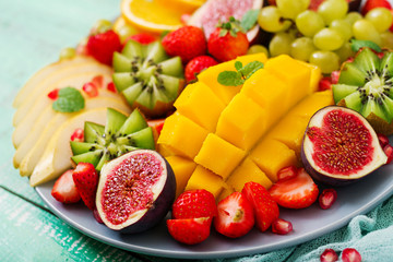 Platter fruits and berries. Mango, kiwi, fig, strawberry, grapes, pear and orange. Vegan cuisine. Dietary menu.
