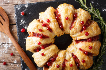 Christmas food: pie with meat, cranberries, rosemary and cheese close-up. horizontal top view