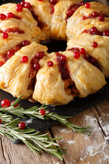 Festive meat puff cake with cranberry, rosemary and cheese close-up. vertical