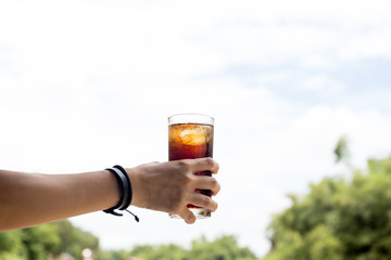 Hand hold the glass of fizzy drink