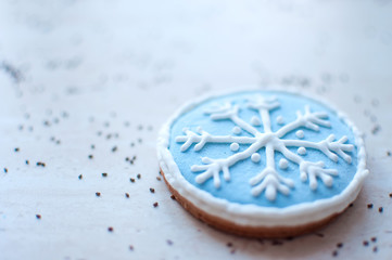 Fototapeta na wymiar A Christmas gingerbread cookie in the shape of a blue round snowflake close-up. Selective focus, bokeh.