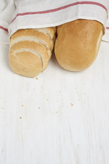 Freshly baked bread on white wooden table with Tablecloth and copy space