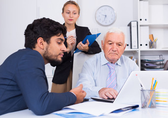 Obraz premium Mature man is talking to colleague
