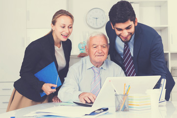 Fototapeta premium Managers are demonstrating reports on laptop to mature boss