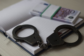 handcuffs and money Notepad on the table