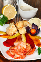 Grilled shrimp served with vegetables and lemon.