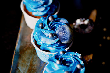 Incredible cosmic blue cupcakes with decoration in the form of round planets. A work of culinary art