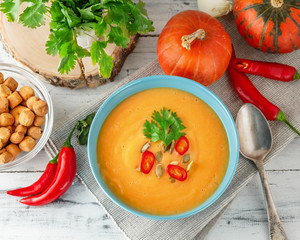 Spicy pumpkin soup with chili pepper in bowl