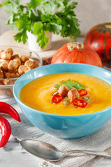 Spicy pumpkin soup with chili pepper in bowl