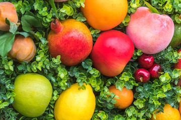 Colorful fruit on green grass, background