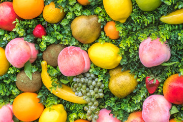 Variety colorful fruit on green grass, background
