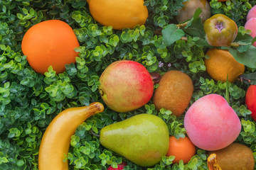 Fototapeta na wymiar Mix of colorful fruit on green grass, background