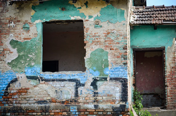 detail of old green ruined house without door and window