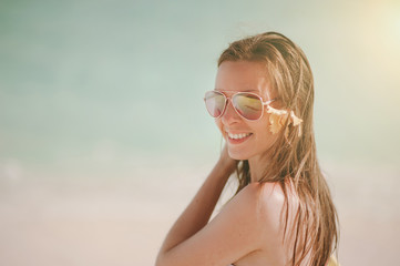 Beautiful European smiling happy woman in sunglasses on the beach in Maldives in Indian Ocean from aerial view. Piece of paradise on the Earth. Good choice for vacation.