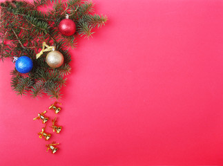 Christmas decoration with Beautiful gold bells, colorful balls and ribbons on red background.