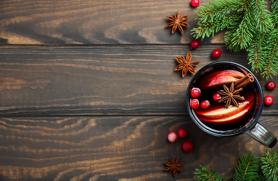 Christmas Mulled Wine with Apple and Cranberries. Holiday Concept Decorated with Fir Branches, Cranberries and Spices. Top View Flat Lay Copy Space.