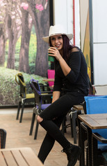 Beautiful girl drinking coffee at the coffee shop