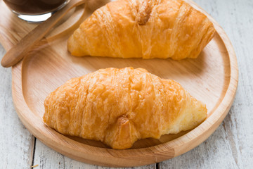 Tasty croissants on white wood background