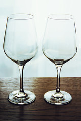 Two empty wine glasses on wooden table close up