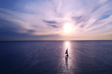 Romantic frame: yacht floating away into the distance towards the horizon in the rays of the...