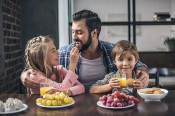 father and children having breakfast