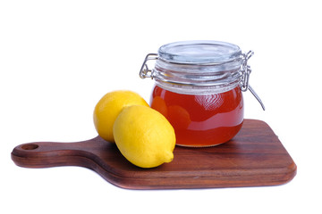 Alternative medicine with lemon  and  honey on wooden cutting board over white background