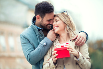 Couple in love.Man surprising his girlfriend with a gift.