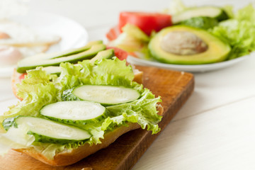 Sliced tomatoes, cucumber and salad leaves on a fresh ciabatta bread