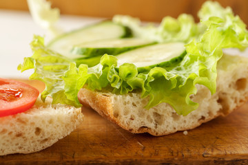 Sliced tomatoes, cucumber and salad leaves on a fresh ciabatta bread