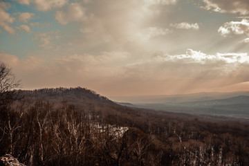 Obraz premium mountain peaks in a foggy air and sunrays seen through the clouds