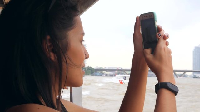 Young Mixed Race Tourist Girl Cruising on Small Thai Boat and Taking Photos Using Mobile Phone. Bangkok, Thailand. 4K, Slow Motion.