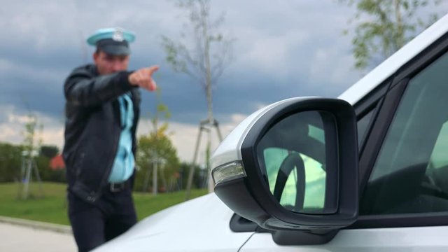 A young police officer walks to a pulled-over car, sees something, pulls out a gun and shouts at the driver
